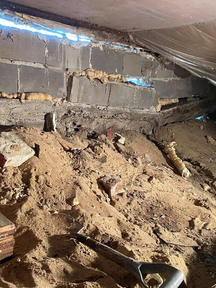 Foundation jobsite with a cinder block wall and fresh excavation